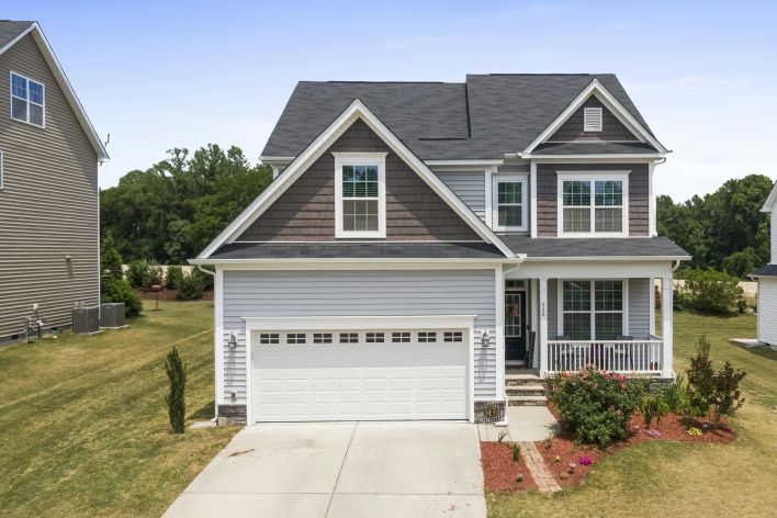 Aerial view of a modern suburban house in Fuquay-Varina with a well-maintained lawn and driveway.